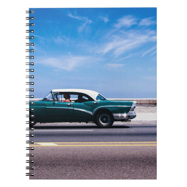 Green coupe on grey asphalt road notebook (Front)