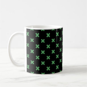 Green cross stitches on black coffee mug