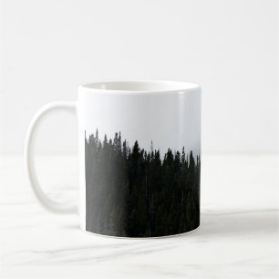 GREEN EVERGREEN TREES UNDER A CLOUDY SKY COFFEE MUG