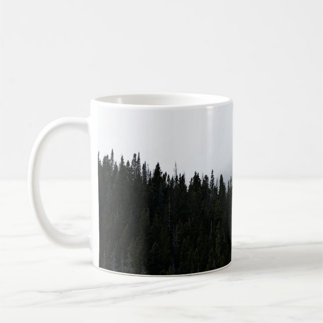 GREEN EVERGREEN TREES UNDER A CLOUDY SKY COFFEE MUG (Left)