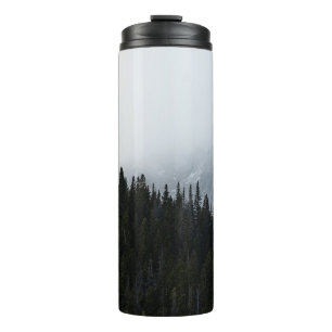 GREEN EVERGREEN TREES UNDER A CLOUDY SKY THERMAL TUMBLER