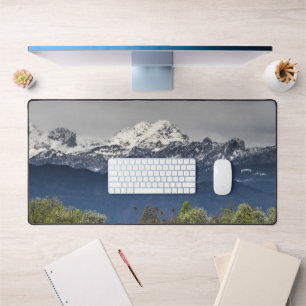 Green field with snowy alps desk mat