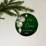 Green gold white baubles Christmas Ceramic Ornament<br><div class="desc">A rustic green uneven coloured background. Decorated with white and gold baubles and some greenery and a pine cone.  Personalise and add your name,  year.  Text: Merry Christmas</div>