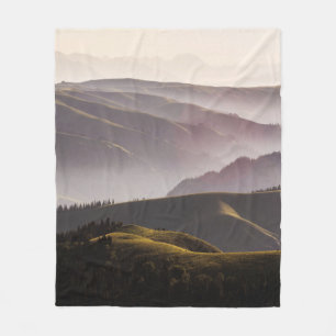 GREEN GRASS FIELD AND MOUNTAINS DURING DAYTIME FLEECE BLANKET