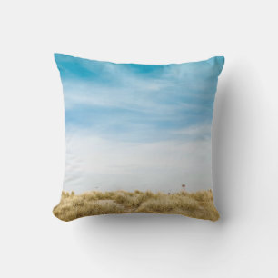 Green grass field under blue skies cushion