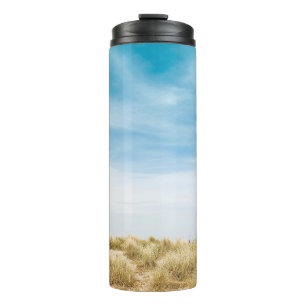 Green grass field under blue skies thermal tumbler