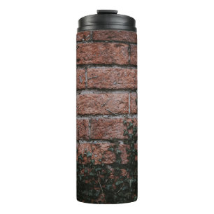 Green-leafed plants near brick wall thermal tumbler