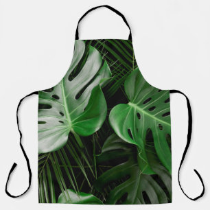 Green monstera leaves and palm leaves apron