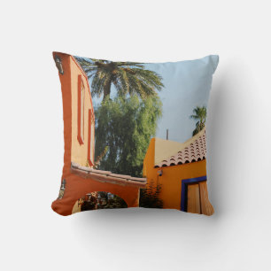 Green palm tree beside brown concrete building in cushion