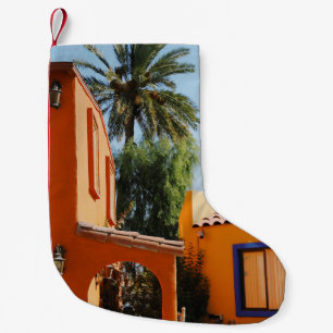 Green palm tree beside brown concrete building in small christmas stocking