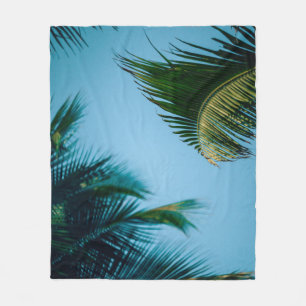 Green palm tree under blue sky in the morning fleece blanket