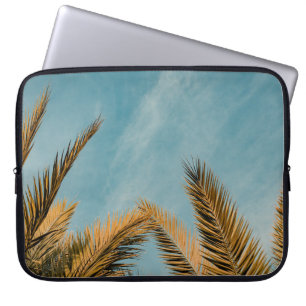 Green palm tree under blue sky in the morning laptop sleeve