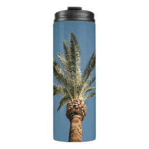 Green palm tree under blue sky in the morning thermal tumbler