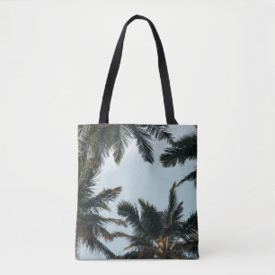 Green palm tree under white sky in the morning tote bag