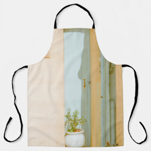 GREEN PLANT WITH CERAMIC VASE BESIDE WHITE WOODEN APRON