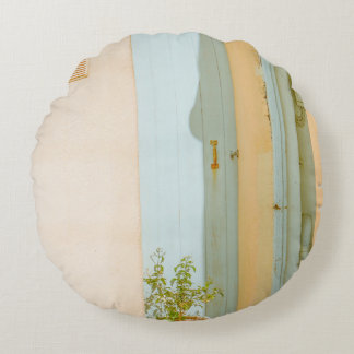 GREEN PLANT WITH CERAMIC VASE BESIDE WHITE WOODEN ROUND CUSHION