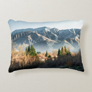 GREEN TREES NEAR SNOW COVERED MOUNTAIN DURING DAYT DECORATIVE CUSHION