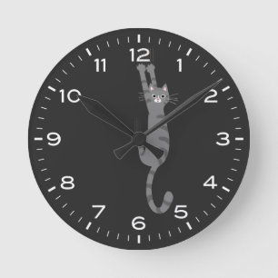 Grey Tabby Cat Hanging On Funny Round Clock