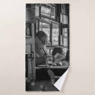 GREYSCALE PHOTO OF MAN SITTING WHILE READING NEWSP BATH TOWEL