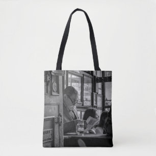 GREYSCALE PHOTO OF MAN SITTING WHILE READING NEWSP TOTE BAG