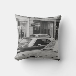 GREYSCALE PHOTOGRAPHY OF CARS ON ROAD BESIDE BUILD CUSHION