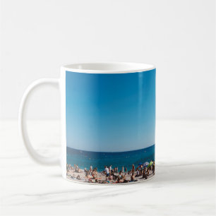 GROUP OF PEOPLE ENJOYING THE GRAY SANDED BEACH WIT COFFEE MUG