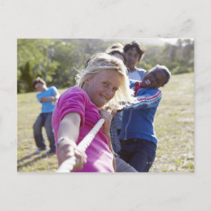 Group of teenagers, aged 13, pulling together postcard