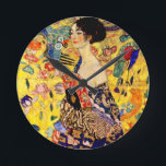 Gustav Klimt Lady with Fan Round Clock<br><div class="desc">Clock featuring Gustav Klimt’s oil painting Lady with Fan (1918). A woman wearing a blue kimono holds a red fan against a colourful yellow background of flowers and peacocks. A great gift for fans of Japonisme and European art.</div>