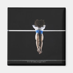 Gymnast (9-10) reaching for uneven bars magnet