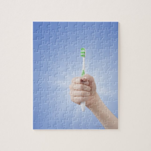 Hand holding tooth brush jigsaw puzzle (Vertical)