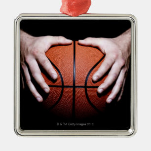 Hands holding a basketball metal tree decoration