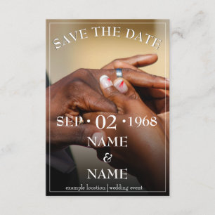 Hands of a coloured wedding couple pin on ring enclosure card
