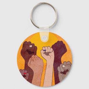 Hands with fist raised up over yellow sun  key ring