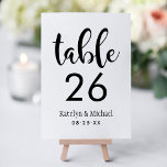 Handwritten Script Wedding Table Number Card<br><div class="desc">Bold black handwritten calligraphy on a clean white background brings modern, artistic energy to this wedding table number card. The couple's names and wedding date are displayed in a relaxed script for a casual yet elegant monogram design. The couple's names, date, and table number are easy to personalise. Each table...</div>