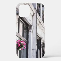 HANG PINK FLOWER ON WHITE CONCRETE BUILDING AT DAY