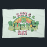 Have a Lucky Day Retro Typography Tea Towel<br><div class="desc">A kitchen towel with a St. Patrick's Day themed image. A retro grunge style design which says: Have a lucky day. With a colourful rainbow behind. Words written in a fat rounded retro style vibe. Pink and green colours.</div>