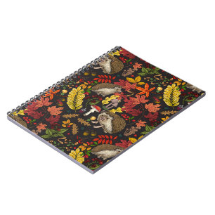 Hedgehogs and autumn forest flora on black notebook