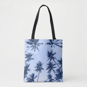High palm trees, clear blue sky. tote bag