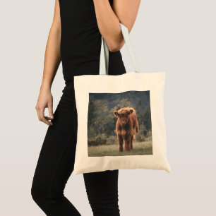 Highland cow calf autumn grass field tote bag