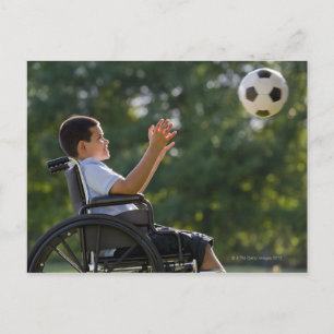 Hispanic boy, 8, in wheelchair with soccer ball postcard