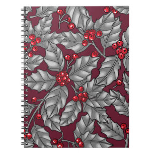 Holly berry, grey leaves on dark red notebook