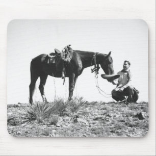 Horse eating from a cowboy's hat. mouse pad