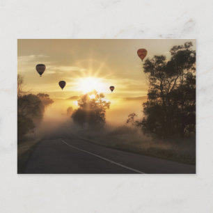 Hot air ballooning over misty landscape postcard