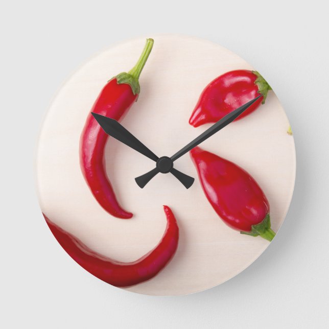 Hot red chilli peppers on a light wooden board round clock (Front)