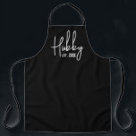 Hubby and wifey kitchen aprons for couple<br><div class="desc">Hubby and wifey kitchen aprons for husband and wife couple. Personalise with your own date of marriage. Trendy BBQ and cooking aprons for him and her. Cute gift idea for wedding anniversary or marriage. Black and white or custom colours. Cool handwritten script typography.</div>