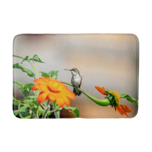 Hummingbird on a flowering plant bath mat
