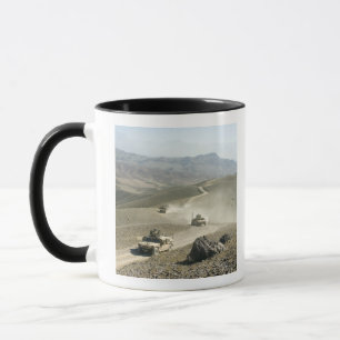 Humvees traverse rugged mountain roads mug