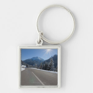 Idyllic empty road thrugh a winter landscape, key ring