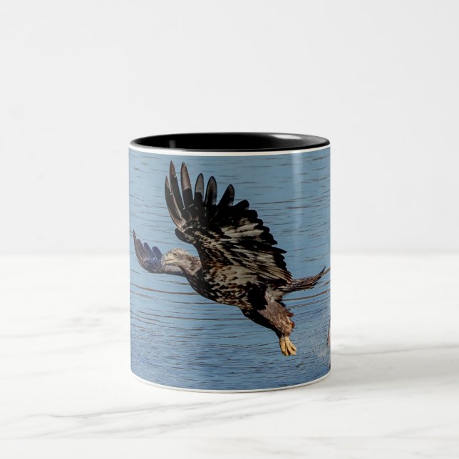 Immature Bald Eagle dropping a fish Two-Tone Coffee Mug (Center)