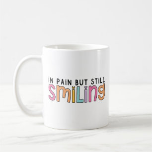 in pain but still smiling coffee mug